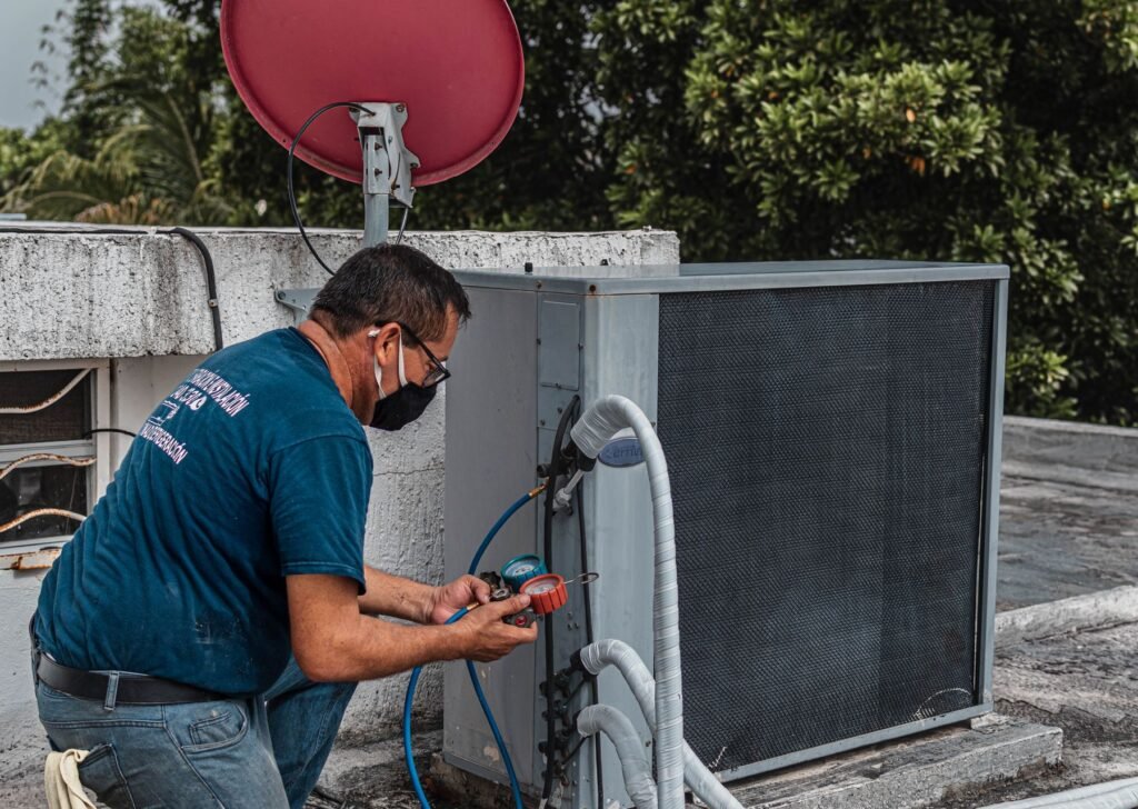 Technician repairing an air conditioner unit for CV Quality Builders