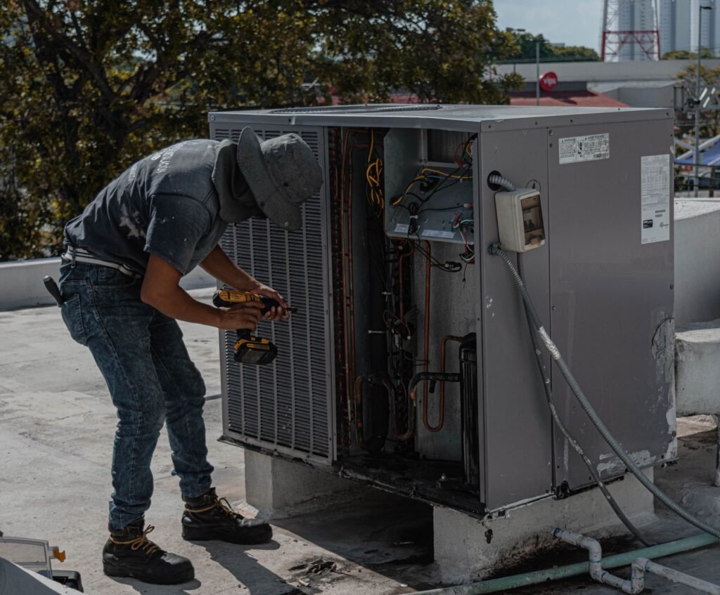 Air conditioning technician servicing a rooftop unit for CV Quality Builders